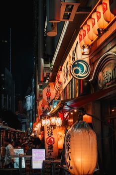 Explore the vibrant night scene in Shinjuku, showcasing illuminated signs and bustling urban life in Tokyo.