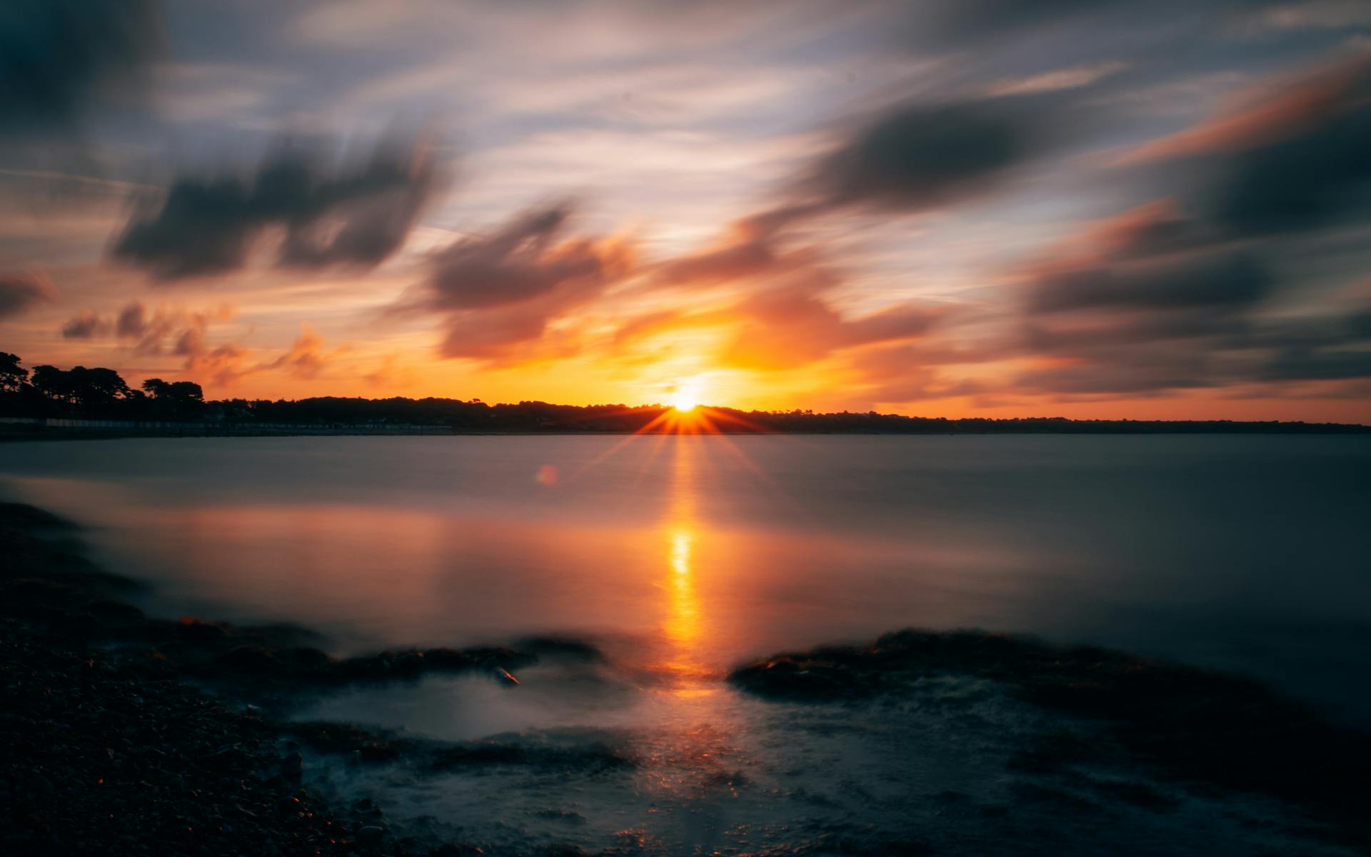Captivating sunset over Christchurch coast with vibrant colors reflecting on the sea.