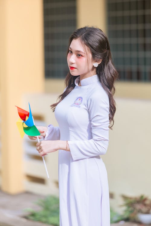 A young woman in a white dress holding a kite