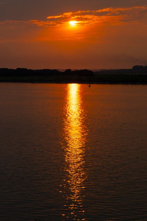 Free Serene sunset with warm orange hues reflecting on a tranquil lake surface, capturing peaceful evening vibes. Stock Photo