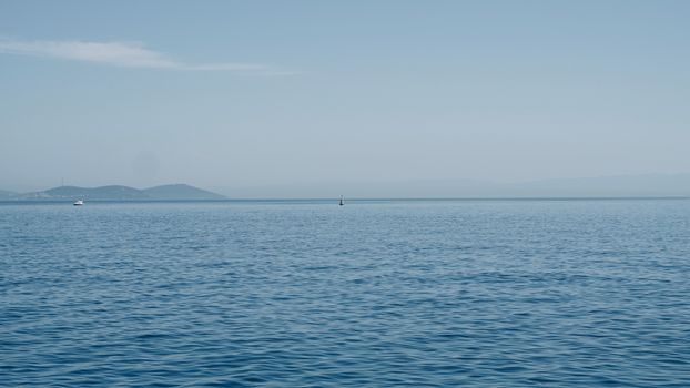 Tranquil view of the open sea with a distant horizon and gentle waves, ideal for travel themes.