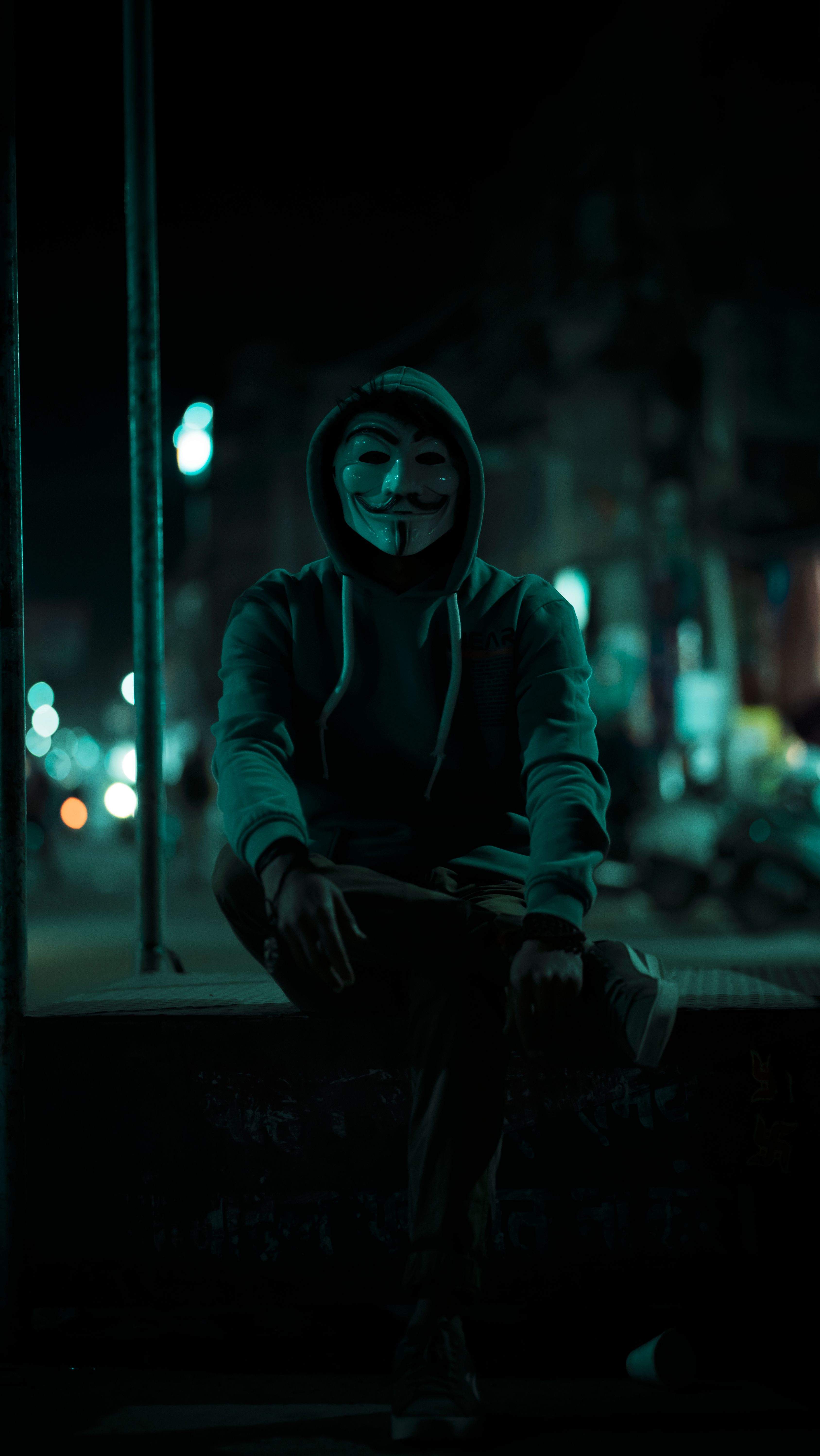 Anonymous Sitting on Wall at Night · Free Stock Photo