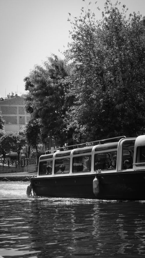 Free Elegant riverboat cruising through a city river in black and white. Stock Photo