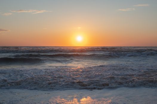Serene sunrise over ocean waves with a clear horizon highlighting the beauty of nature.