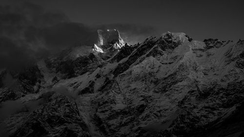 Free Black and white photo capturing the snow-covered Kedarnath mountain range with dramatic lighting and clouds. Stock Photo