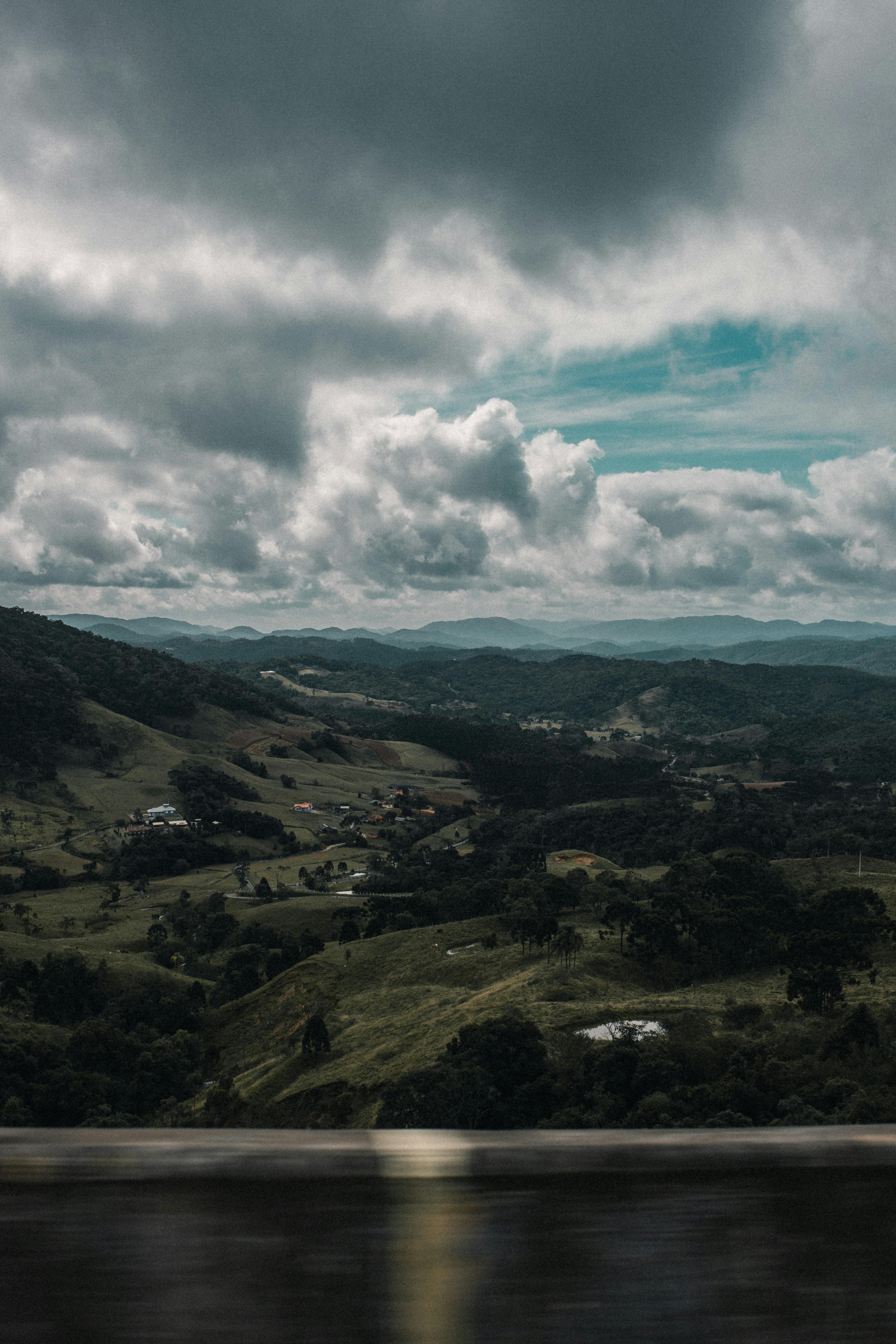 巨大的云层在郁郁葱葱的绿色乡村和远处的山脉上投下阴影