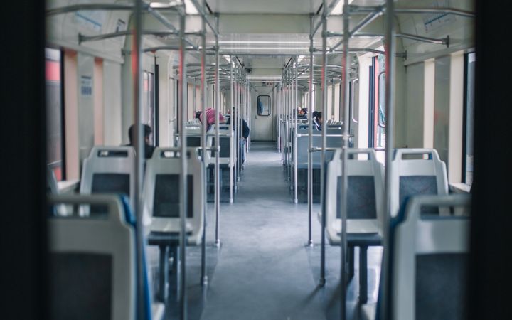 View inside a modern urban train showing empty seats and a clean interior design.