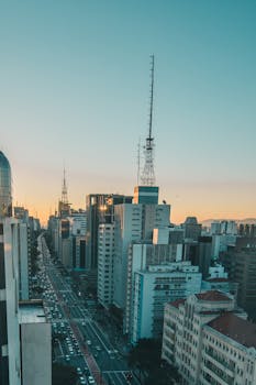 Aerial view of São Paulo's bustling cityscape during dawn, featuring skyscrapers and a vibrant skyline.