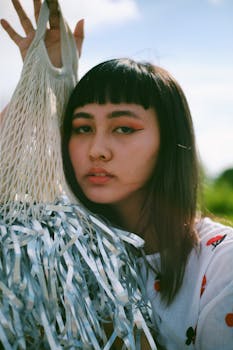 年轻女子拿着净购物袋，背景是户外的蓝天