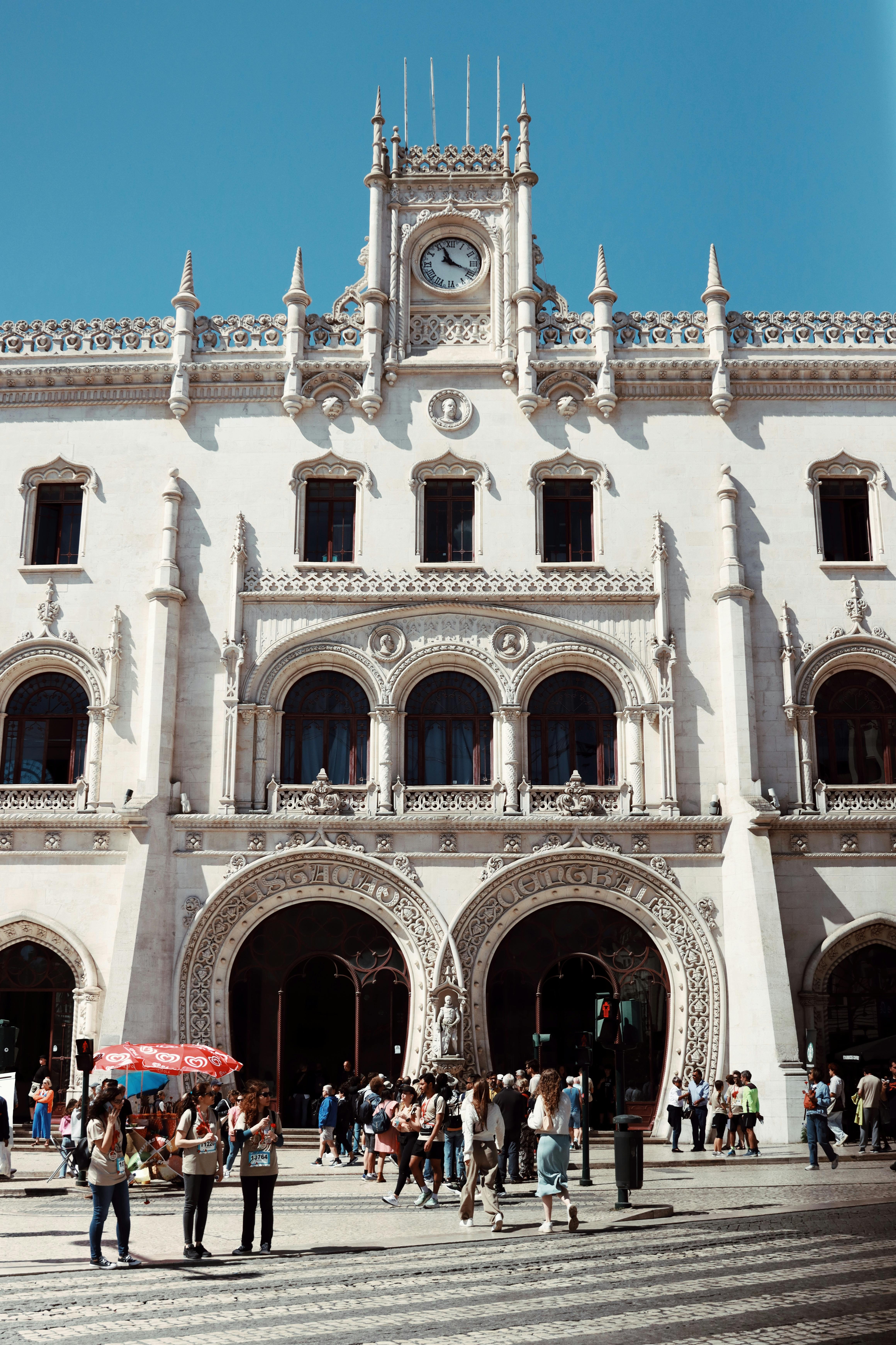 Exterior view of the ornate Gothic-style Rossio Railway Station in Lisbon, Portugal, on a sunny day.