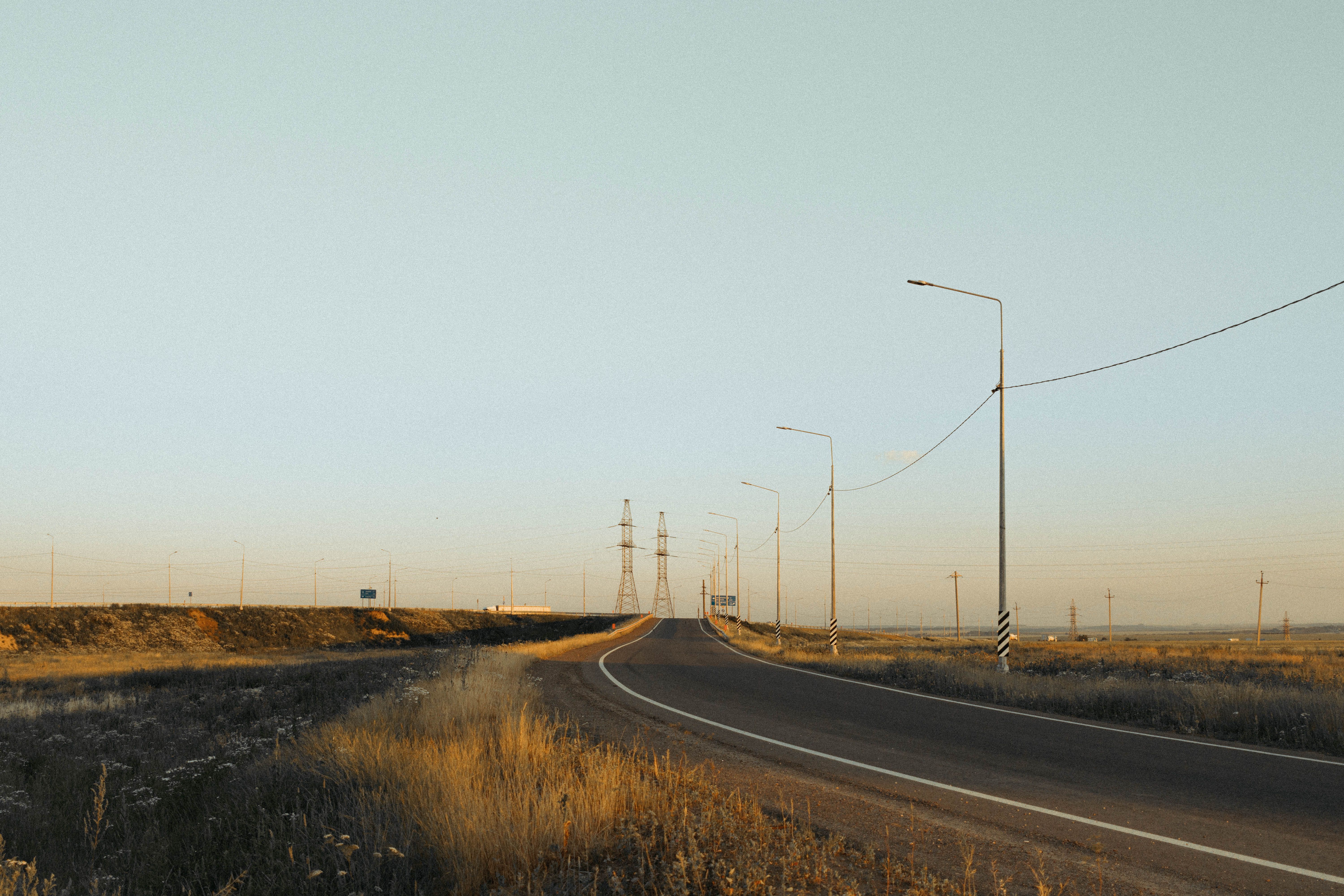 A quiet rural road stretching toward the horizon at dusk