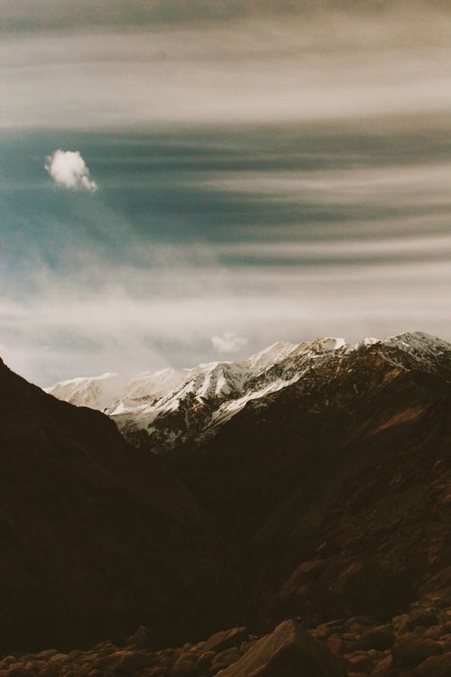 Free Stunning landscape of snow-capped mountains with a dramatic sky above, evoking adventure. Stock Photo