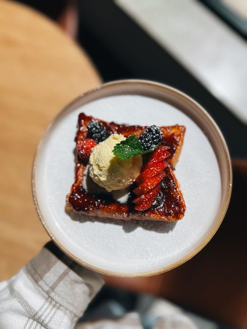 Close-up of a decadent waffle dessert adorned with berries and ice cream, perfect for food lovers.
