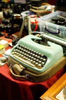Classic vintage typewriter with accessories on display table, showcasing retro appeal.