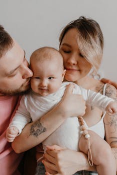 Heartwarming family portrait featuring parents and baby in an intimate embrace.