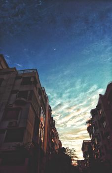 达卡日落时分的城市街景迷人，一轮新月悬于城市景观之上