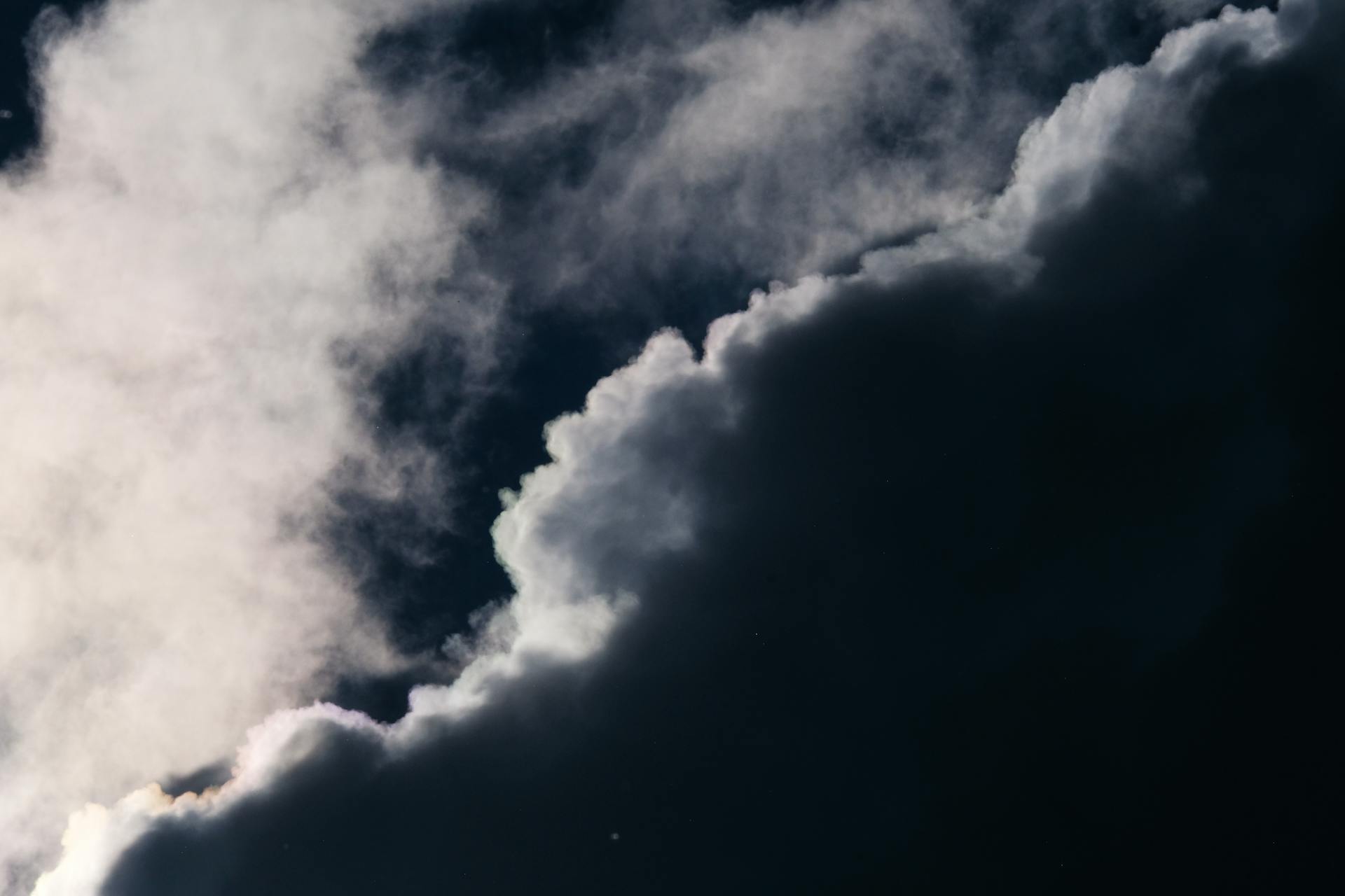 A captivating view of dramatic clouds with sunlight creating a stark contrast in the sky.