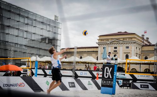Free Exciting beach volleyball action captured in a bustling city environment. Stock Photo