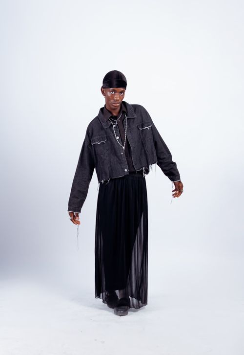Free Modern fashion photography featuring a stylish Nigerian model in eclectic attire with a white studio backdrop. Stock Photo