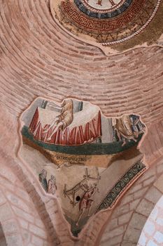 A detailed low angle shot of a vintage ceiling mural in a historic church, showing religious art.