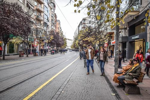 Free Bustling street scene in Eskişehir, Turkey, with people, shops, and tram tracks. Stock Photo