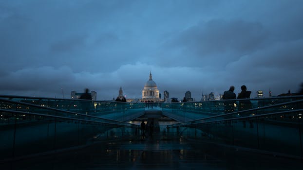 Dramatic evening shot of St Paul's Cathedral in London from Millennium Bridge with silhouettes.