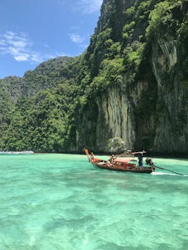 乘坐泰国传统长尾船，可以欣赏到碧绿海水中郁郁葱葱的石灰岩悬崖