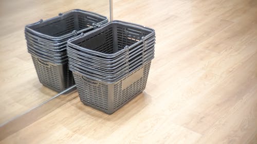 High angle view. A stack of black plastic  shopping baskets near the mirror glass wall