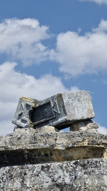 Fotomural Vista de antiguas ruinas de piedra en Pamukkale, Turquía, con cielos azules claros y nubes.