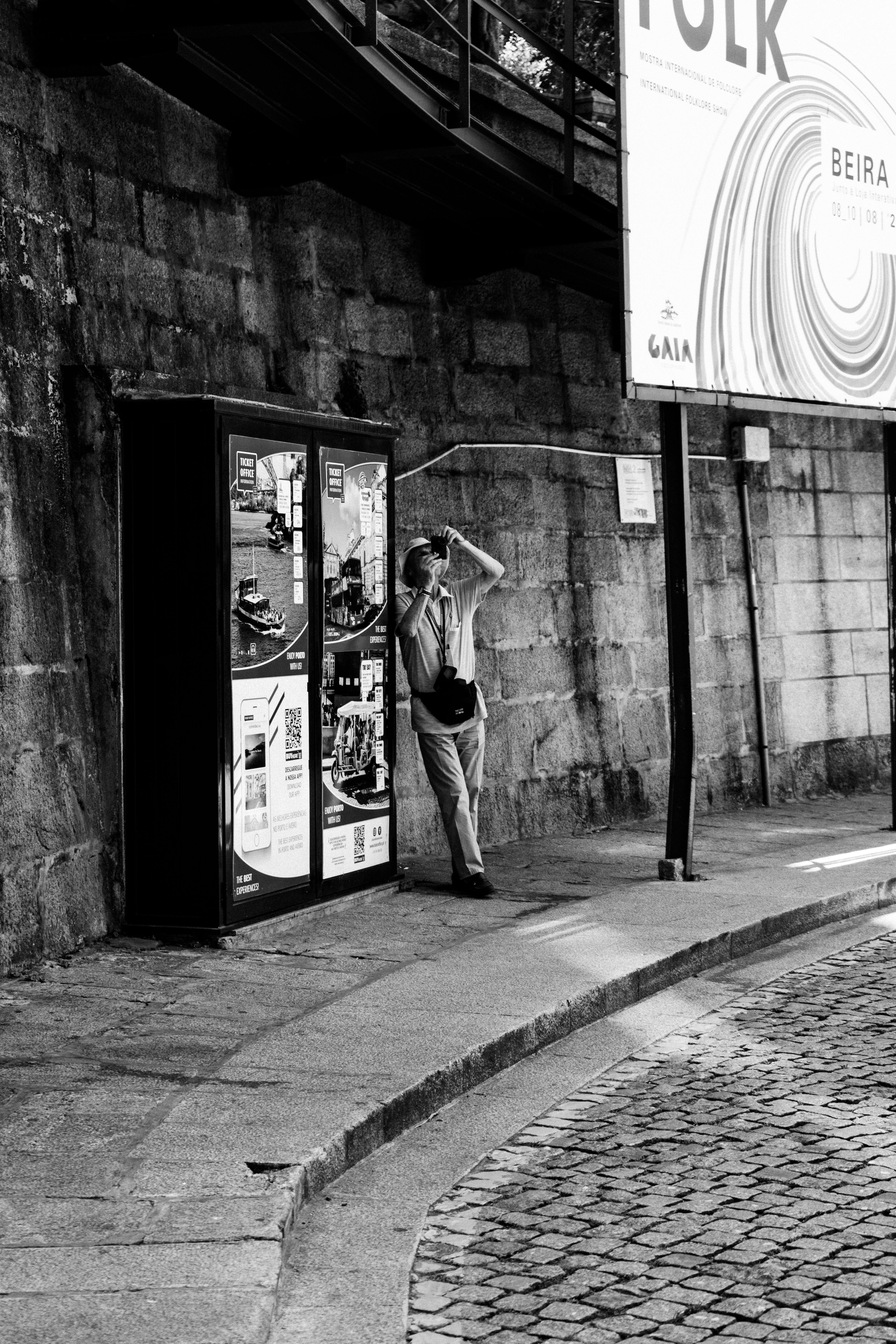 Candid black and white street photo capturing urban life in Porto, Portugal.