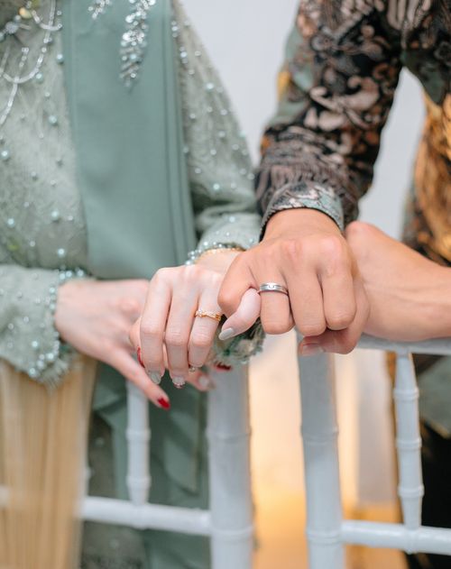 Free Intimate close-up of a couple holding hands in traditional wedding attire. Stock Photo