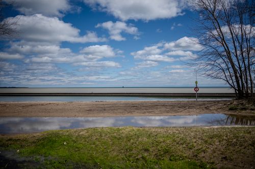 Free A tranquil beach scene with a vibrant blue sky and reflective pool, perfect for relaxation themes. Stock Photo