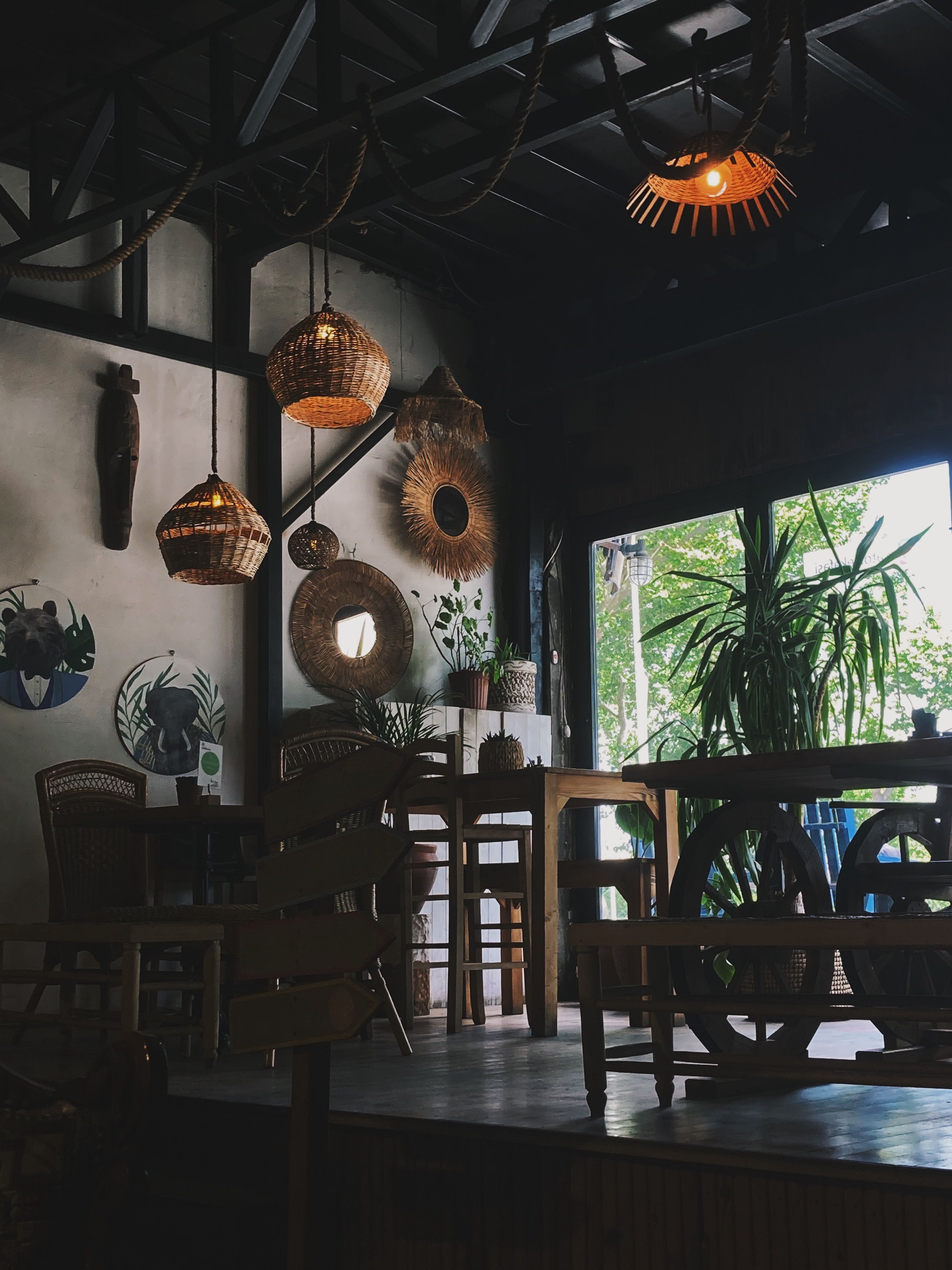 Warm and inviting cafe interior featuring wooden furniture and wicker accents with abundant natural light.