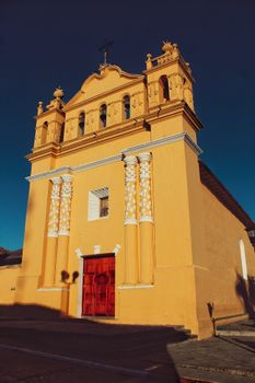Historical Templo del Calvario with vibrant yellow facade in Comitán de Domínguez, Chiapas, Mexico.