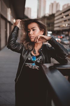 白天，一位时尚女性在繁华的城市中倚着金属栏杆摆姿势