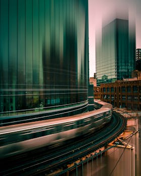 一张长时间曝光拍摄的夜间火车经过芝加哥现代摩天大楼的照片