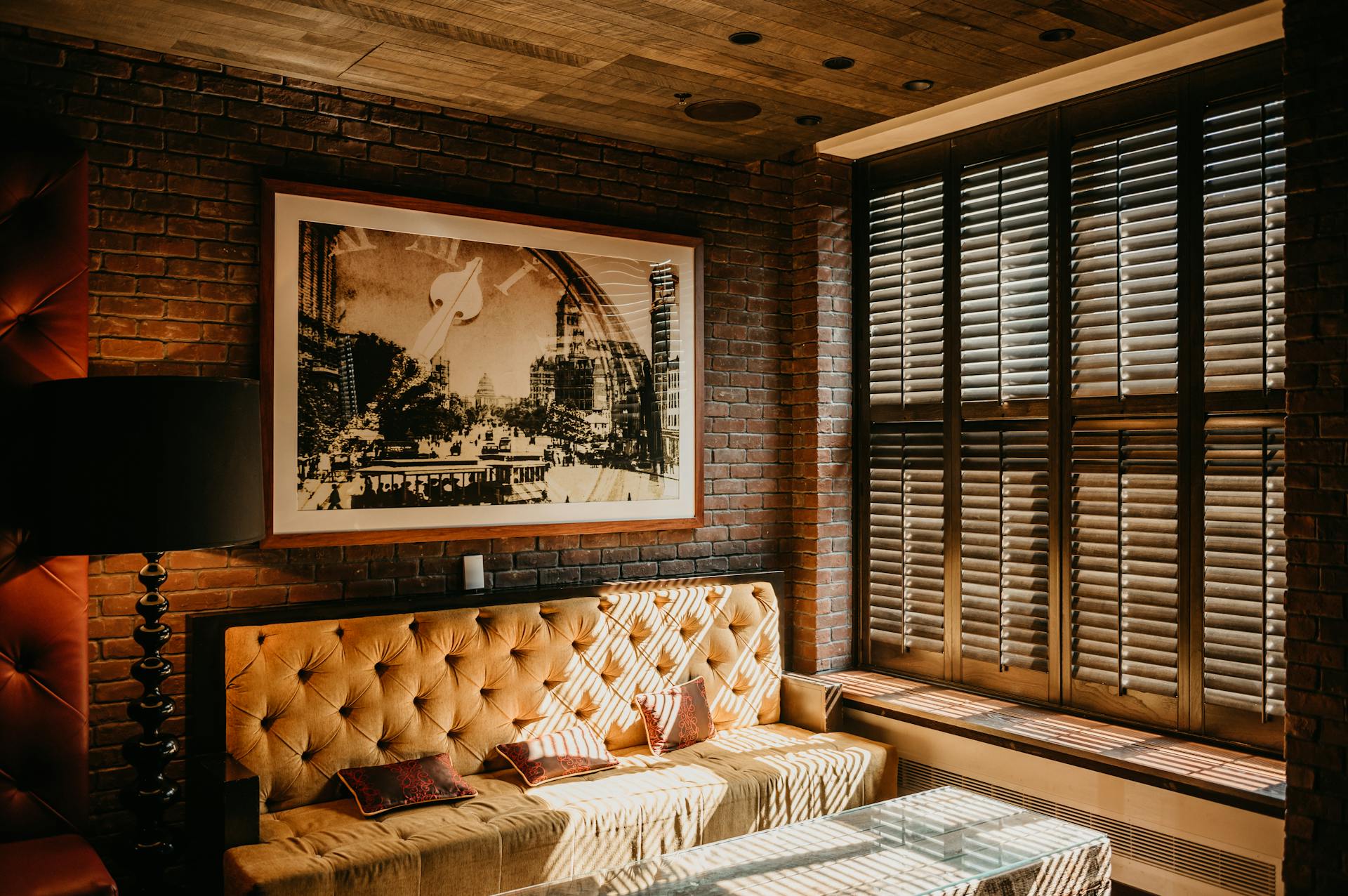 Warm and inviting living room featuring modern decor with a brick wall and ample daylight.