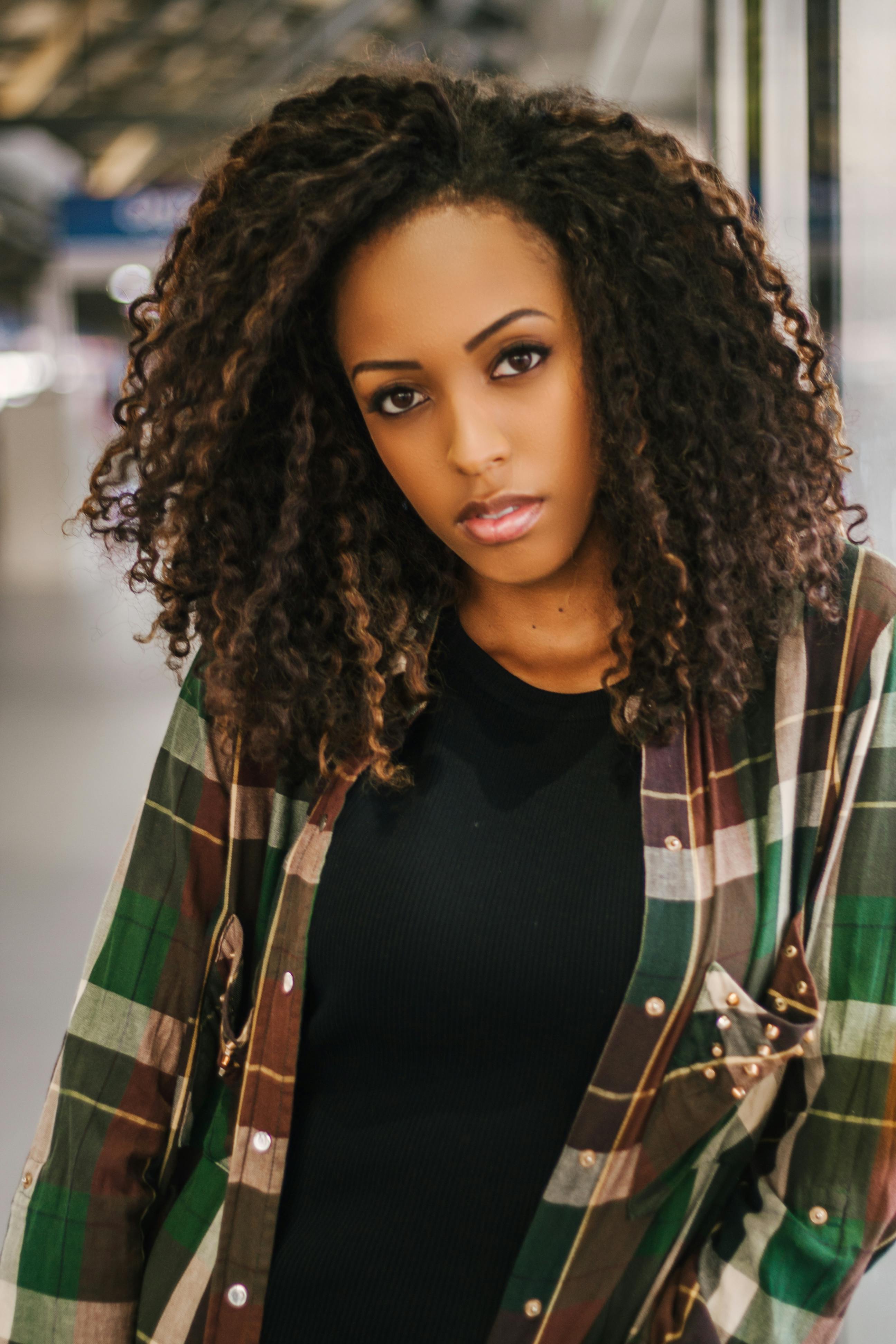 Stylish woman posing indoors in São Paulo, showcasing natural beauty and fashion.