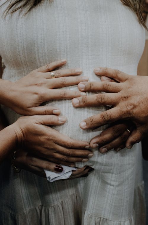 Free Close-up of hands embracing a pregnant belly, symbolizing love and family support. Stock Photo