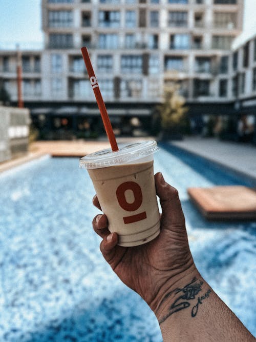 A person holding up a cup of coffee with the number o on it
