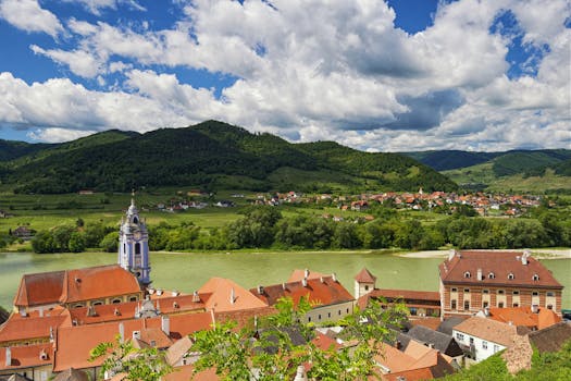 A stunning aerial view of Dürnstein, Austria with the Danube River and lush green hills.