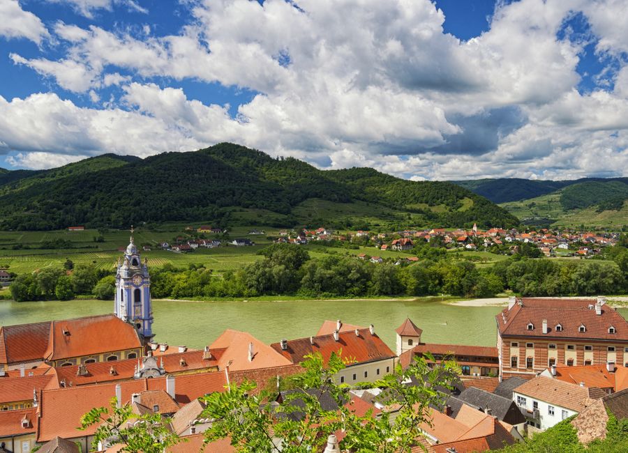 A stunning aerial view of Dürnstein, Austria with the Danube River and lush green hills.