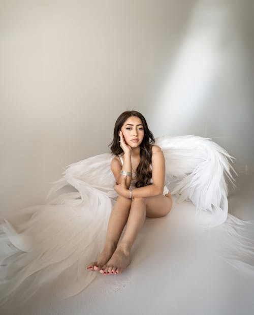 A beautiful woman sitting on a white sheet