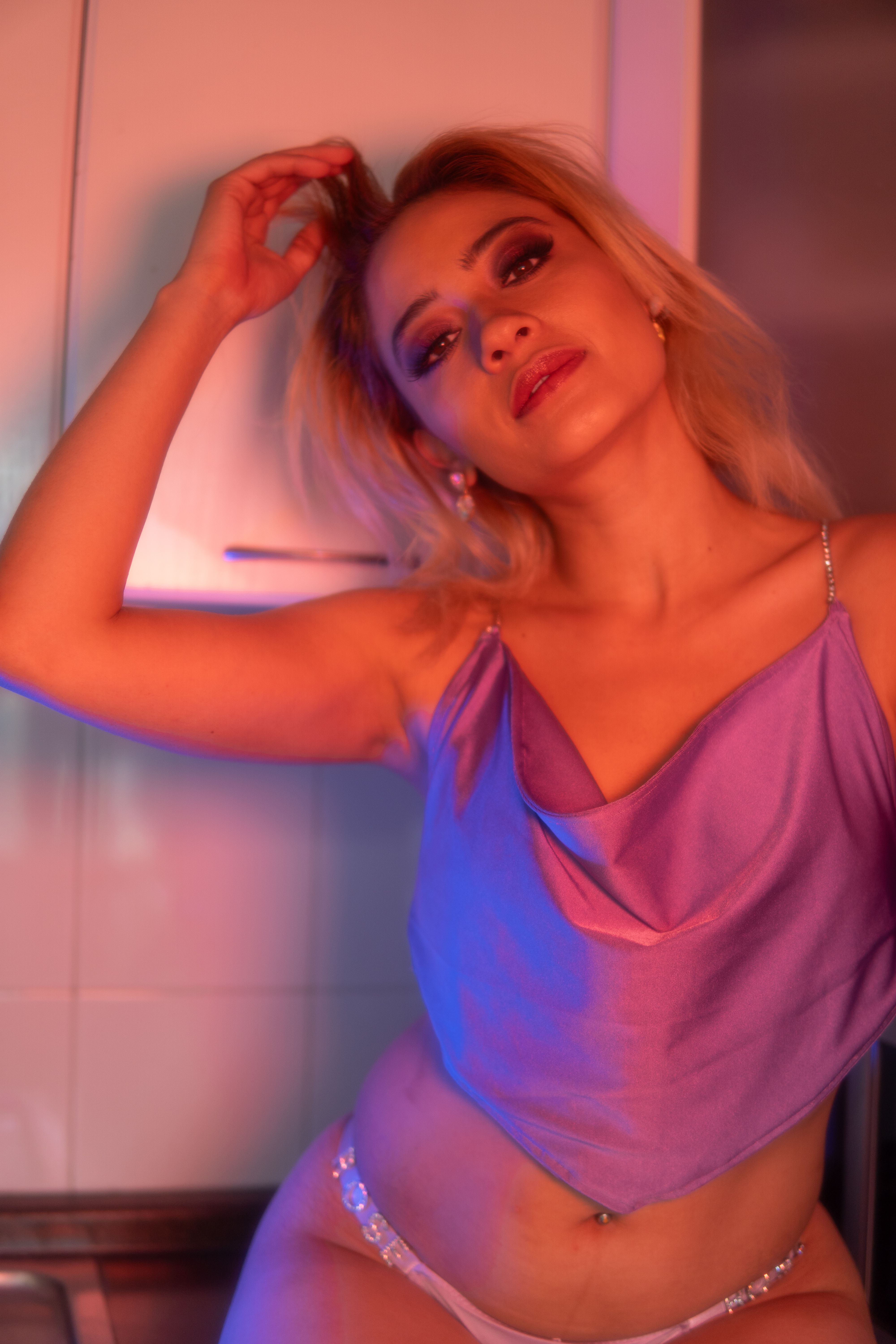 Stylish portrait of a woman posing in a satin top. Artistic lighting in a modern setting.