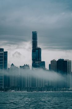 雾笼罩着芝加哥的摩天大楼，海滨在前景中，构成一幅忧郁的景象
