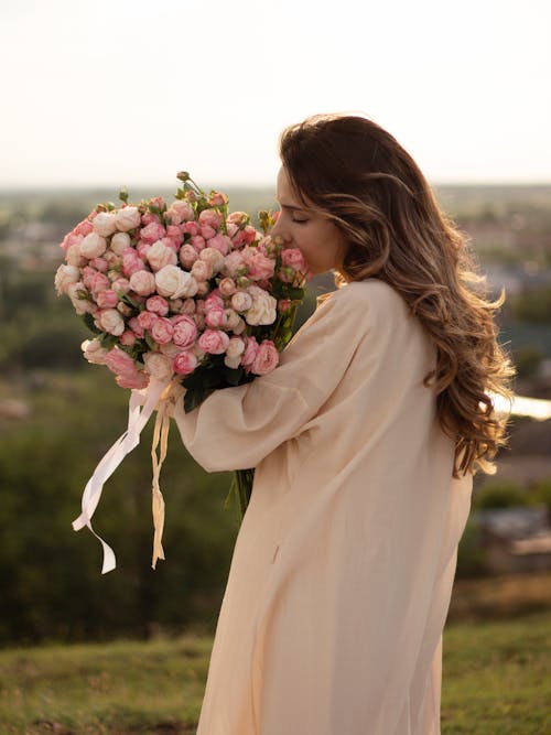 A woman holding a bouquet of pink roses