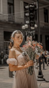 Elegant woman holding a bouquet in urban Heroica Puebla de Zaragoza, Mexico.
