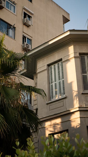 An urban scene featuring a distinctive residential building with intricate architectural details and lush greenery.