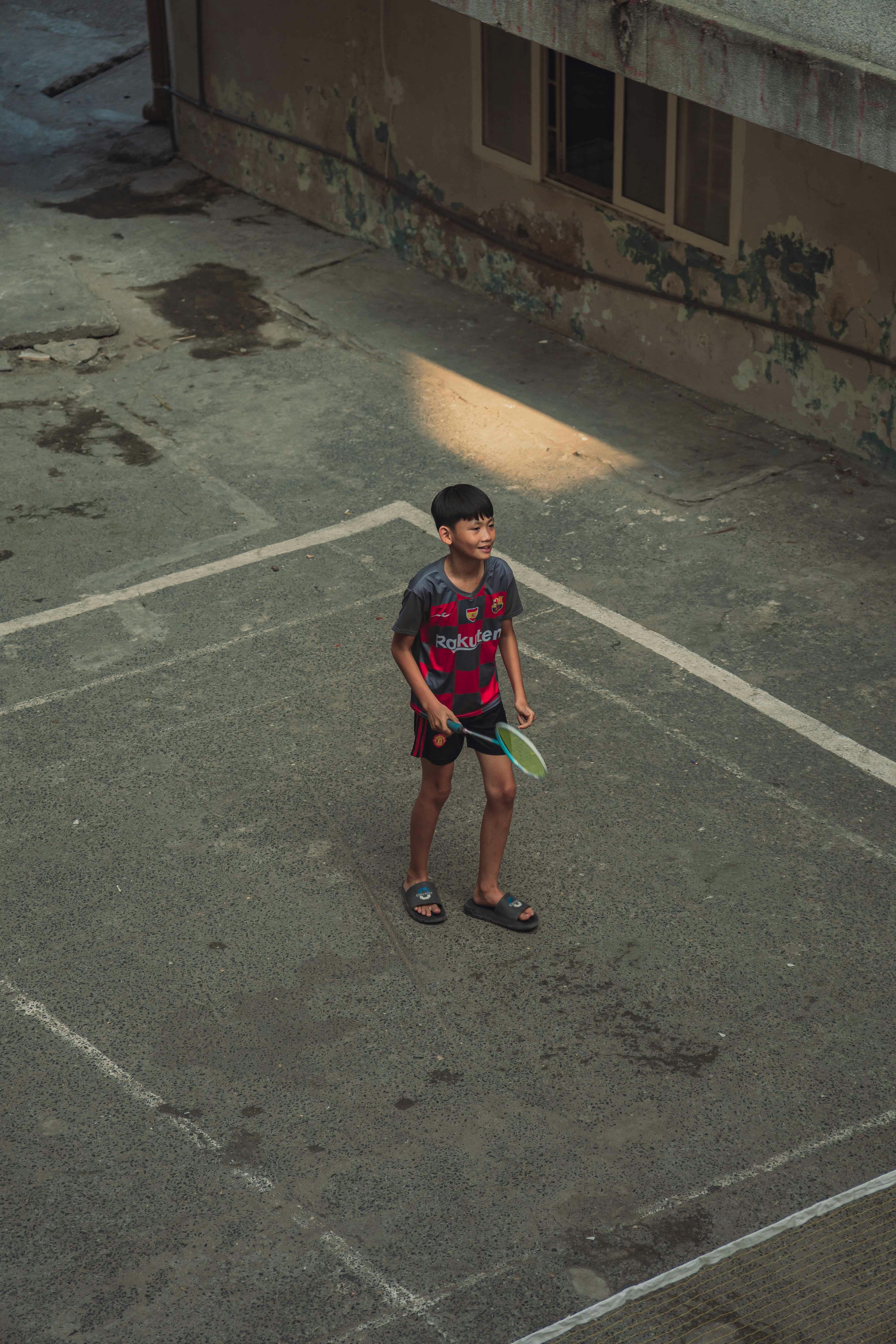 high angle shot of a boy playing badminton outside