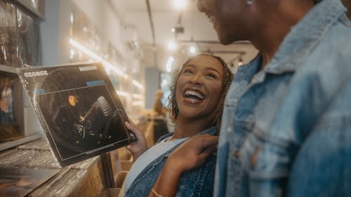 A couple smiling while looking at a record player